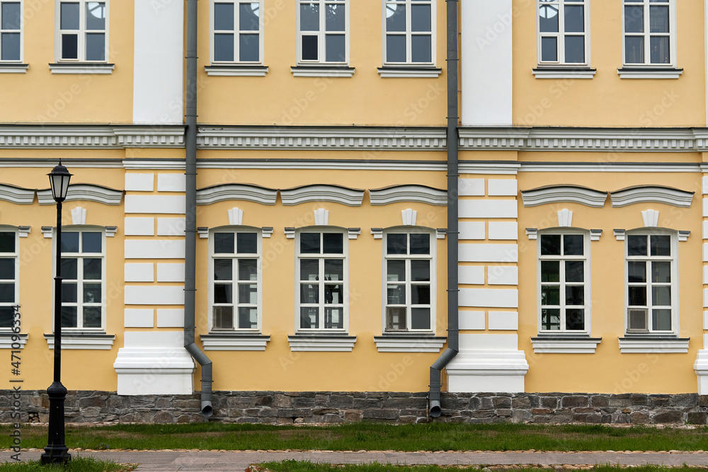 Fragment of the facade of the palace with windows and a yellow wall Fragment of the facade of the palace with windows and a yellow wall