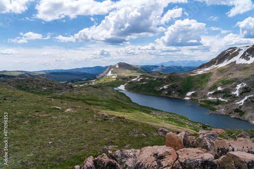 An alpine lake off the Beartooth Highway in the Absaroka Mountains of Wyoming and Montana - snow capped mountains, green grass, blue lake photo