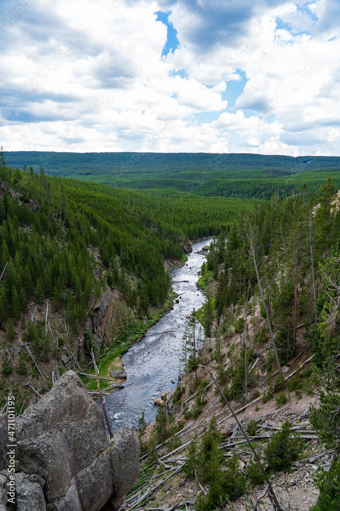 Seen from above, the Gibbon River flows through Yellowstone National Park on a cloudy and sunny summer evening in Wyoming Seen from above, the Gibbon River flows through Yellowstone National Park on a cloudy and sunny summer evening in Wyoming