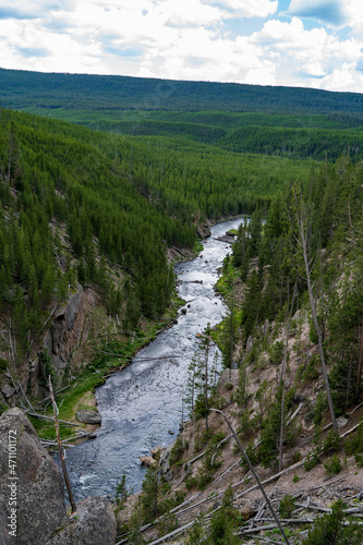 Seen from above, the Gibbon River flows through Yellowstone National Park on a cloudy and sunny summer evening in Wyoming