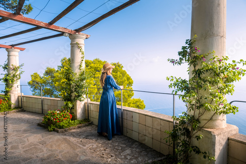 A young blonde girl walking in the patio of an historic villa in Capri island. Capri, Italy. photo