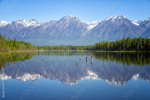 Landscape with mountains reflecting in the water on summer day. Buryatia, Tunkinskaya valley, Russia