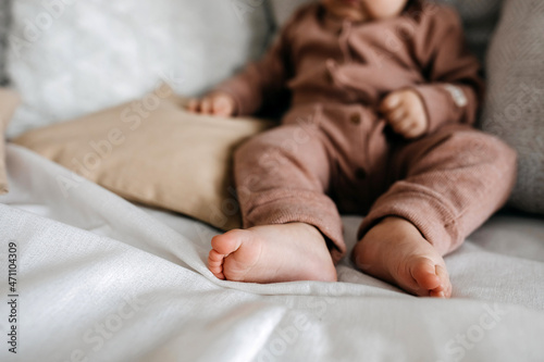 Closeup of baby barefoot feet on bed. photo