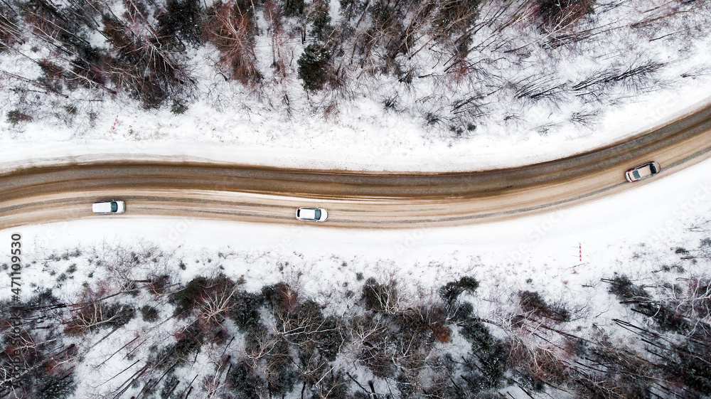 View from a height on a winter road in a snowy forest.