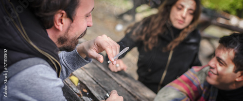 Foto Group of smiling happy young friends smoking marijuana ganja joint