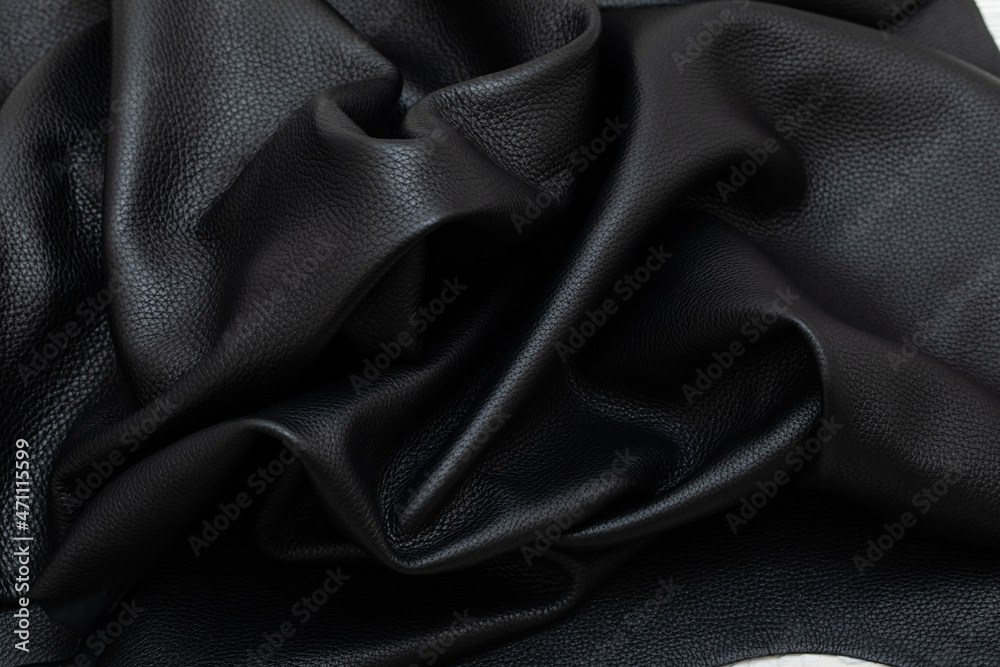 Fototapeta premium Black folded natural cow leather on the wooden table