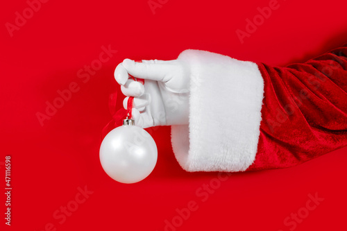 Christmas mockup of a white ball in Santa's hand on red background, Christmas concept, brand.