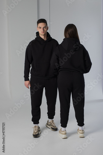 Couple posing in studio wearing black hoodie