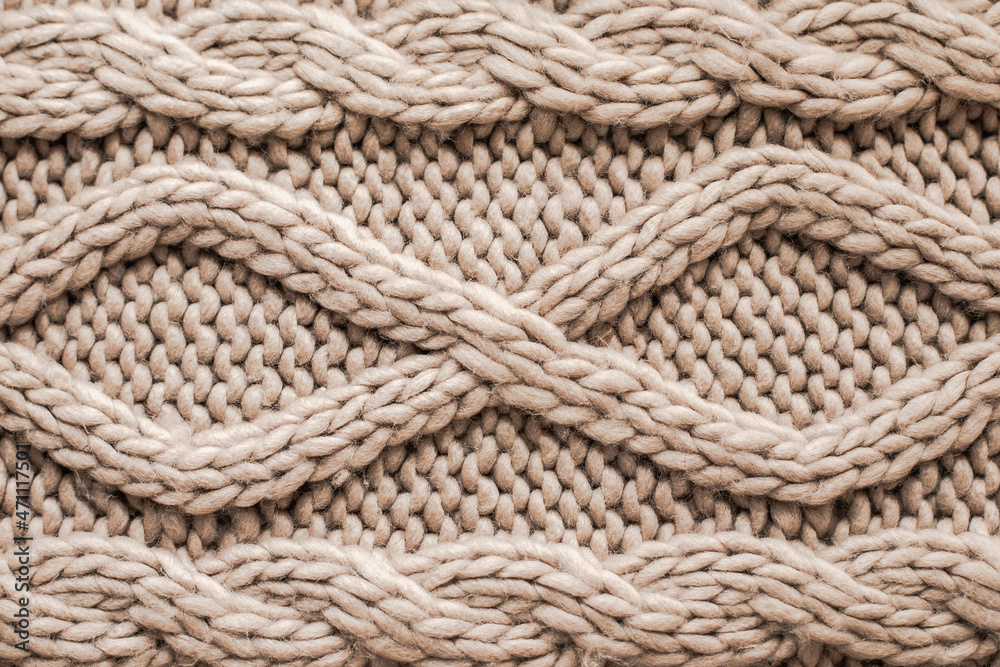 Beige knitting wool texture background. Woolen handmade knitted clothes texture.