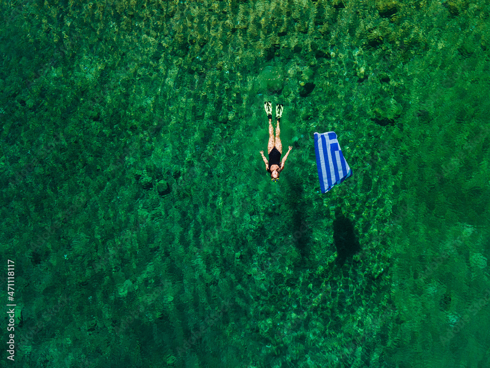 summer greece vacation woman floating in water with flag - obrazy, fototapety, plakaty 