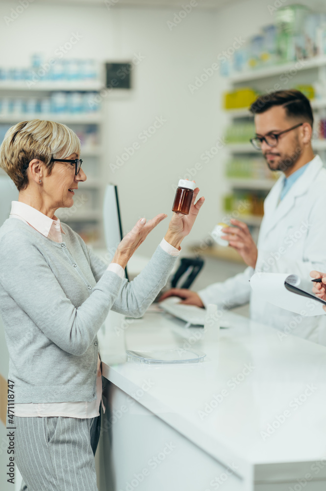 Happy senior woman customer buying medications at drugstore