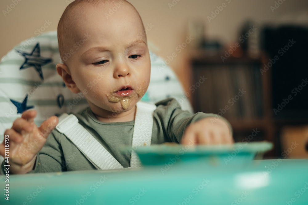 Adorable little baby eating his dinner and making a mess Adorable little baby eating his dinner and making a mess