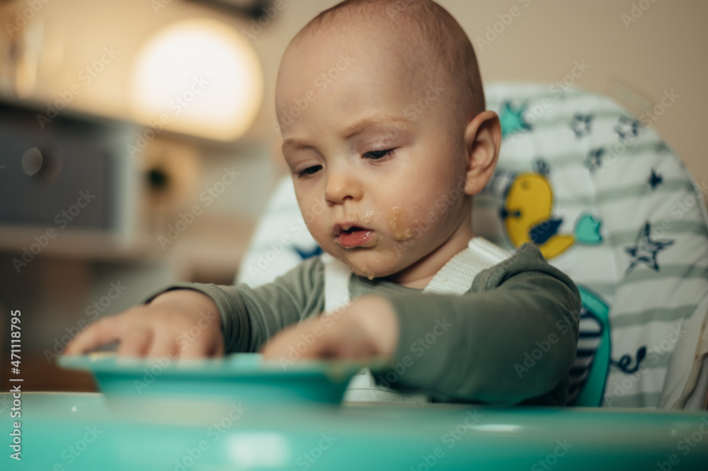 Adorable little baby eating his dinner and making a mess Adorable little baby eating his dinner and making a mess