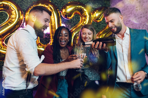 Happy group of friends celebrate New Year's Eve in a club © Zamrznuti tonovi