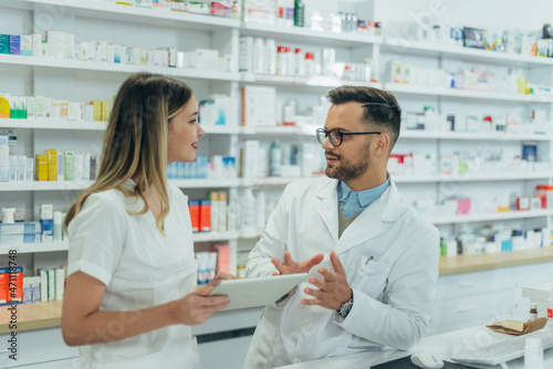 Male pharmacist working with young female colleague in a pharmacy