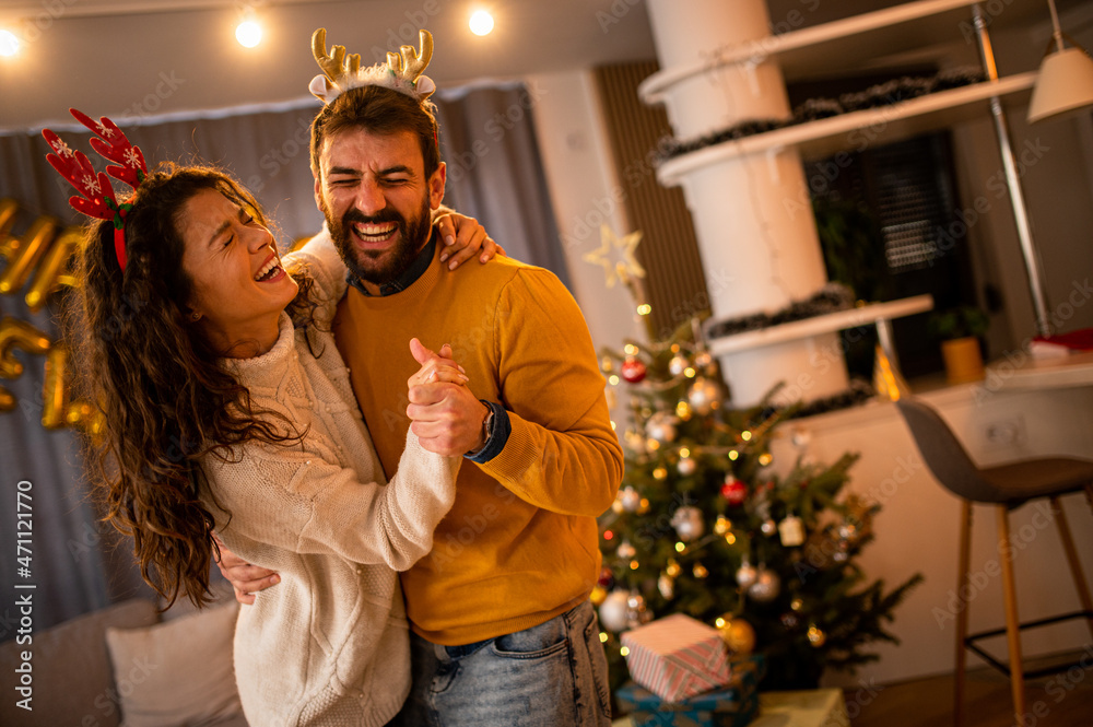 Couple in love having fun alone during New Year's Eve. Happy man and woman in their home during the holidays. Couple in love having fun alone during New Year's Eve. Happy man and woman in their home during the holidays.