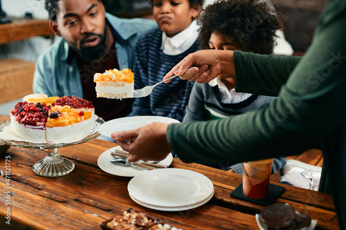 Close-up of black mother serves Birthday cake to her family at home.