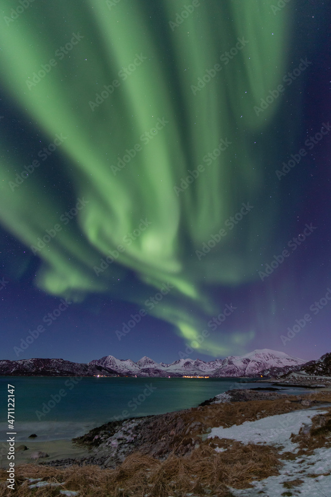 Aurora borealis over fjord in Norway