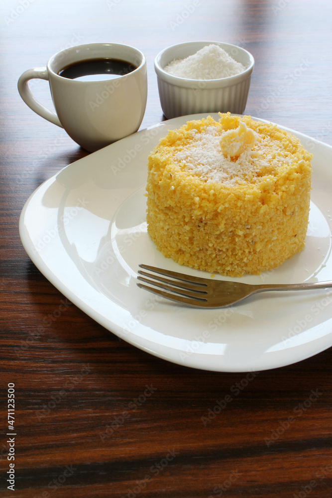 Corn couscous with coconut and cup of coffee. Traditional Brazilian breakfast, especially in northeastern Brazil. Corn couscous with coconut and cup of coffee. Traditional Brazilian breakfast, especially in northeastern Brazil.