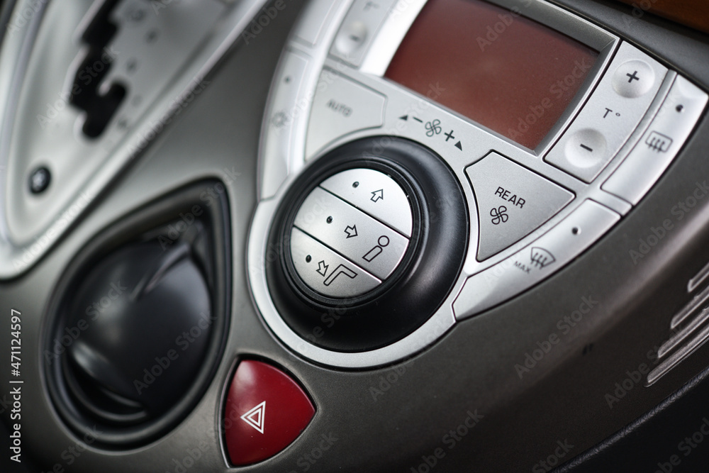 Fototapeta premium Car dashboard interior of modern car. Black cockpit with button and icon for air conditioner option, car window heating buttons and emergency lights button.