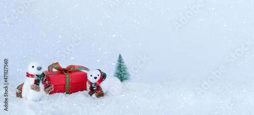 White penguin and polar bear with christmas present on snowy background. Stock photo banner