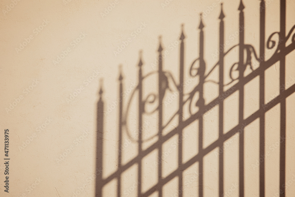 Shadow of an ornate fence on a yellow plaster wall Shadow of an ornate fence on a yellow plaster wall