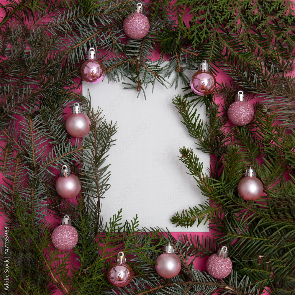 Evergreen trees with Christmas tree decorations on a pink background with copy space in white. Flat lay minimal scene. Evergreen trees with Christmas tree decorations on a pink background with copy space in white. Flat lay minimal scene.