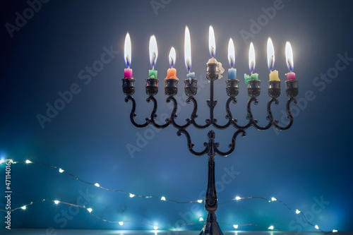 Jewish holiday Hanukkah background with menorah traditional candelabra and candles on blue background