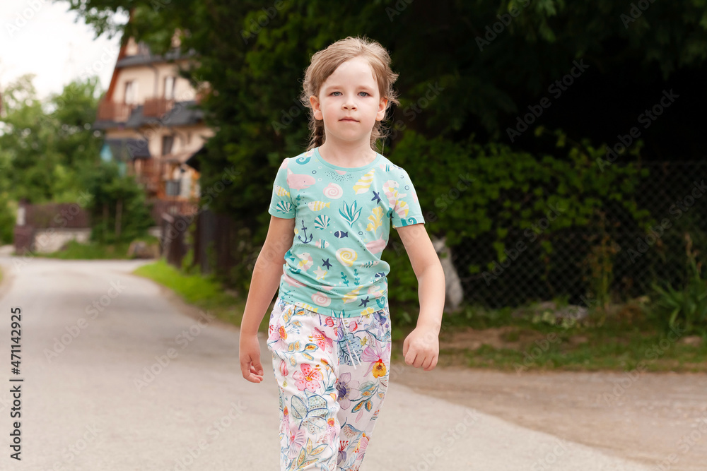 One single young serious confident happy elementary school age girl walking towards the camera outdoors, copy space, closeup, self-confidence personality trait concept, one person, colorful clothes One single young serious confident happy elementary school age girl walking towards the camera outdoors, copy space, closeup, self-confidence personality trait concept, one person, colorful clothes