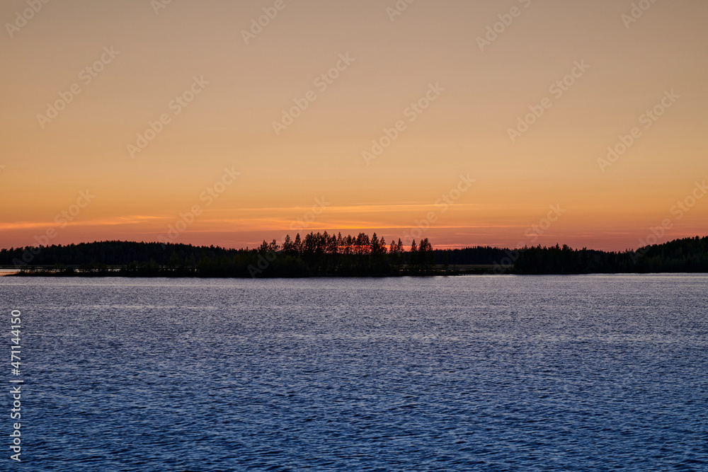 Russia. Onega lip of the White Sea. The sun went over the horizon behind the forest