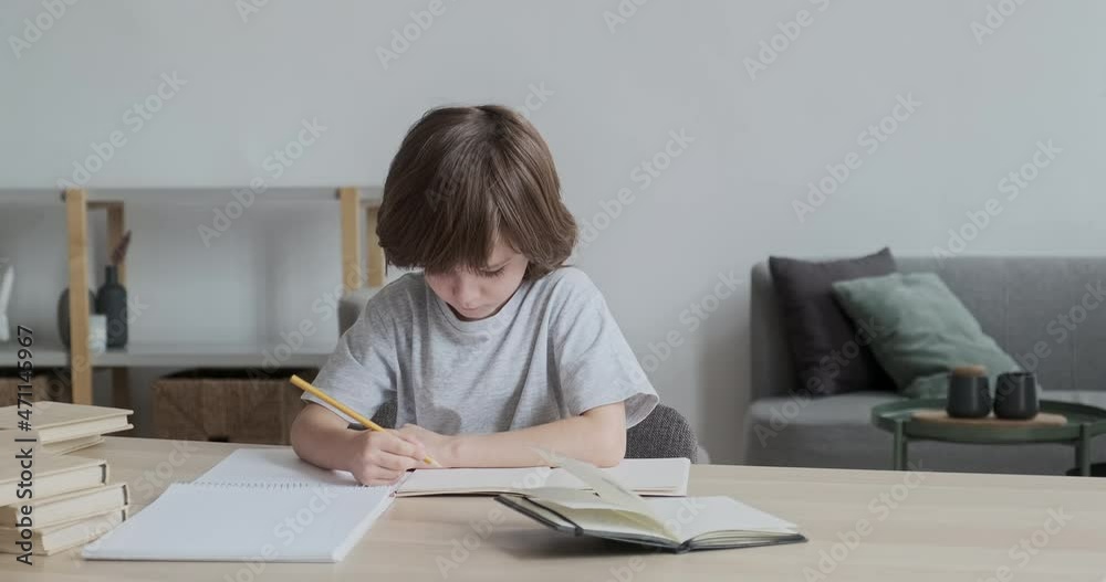 Thoughtful and considerate, attentive, and hardworking 6-year-old kid learning to write and draw at home. Cute child sitting at a desk completing homework for preschool children's education. Thoughtful and considerate, attentive, and hardworking 6-year-old kid learning to write and draw at home. Cute child sitting at a desk completing homework for preschool children's education.