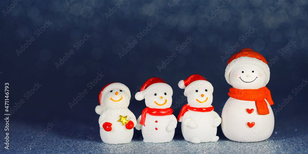 Four snowman figures on a shiny paper background. Christmas decorative smiling snowmen. Horizontal banner. Copy Space Four snowman figures on a shiny paper background. Christmas decorative smiling snowmen. Horizontal banner. Copy Space