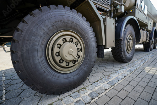 Large military grade tires on green gray army vehicle, closeup detail © Lubo Ivanko