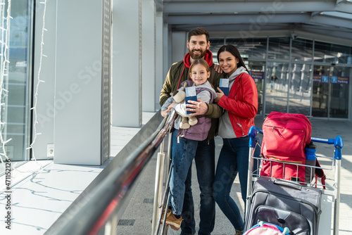 Family with little kid in airport terminal. Traveling by airplane during the vacation. Adventures and emotions concept