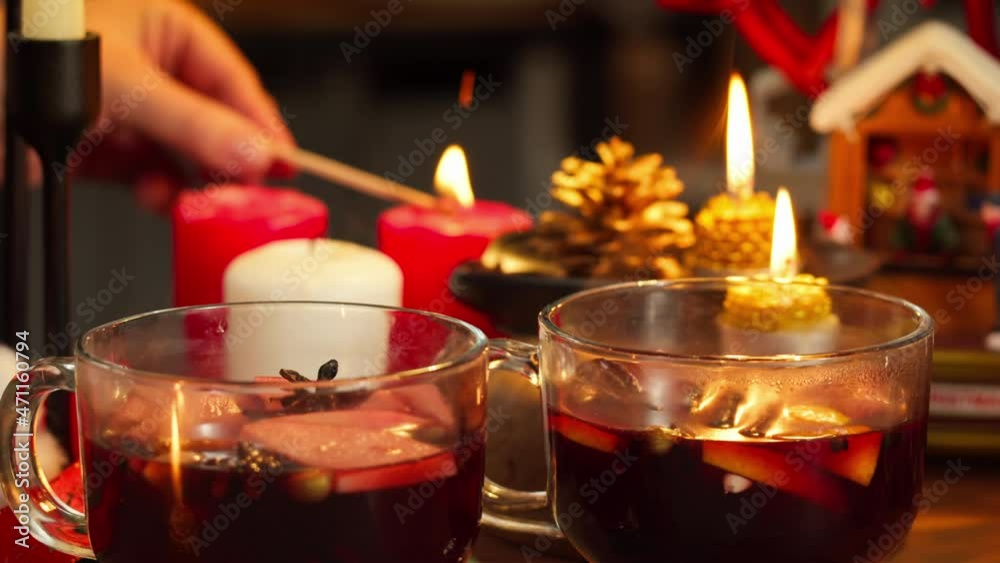 Mulled wine in glasses, gluhwein close-up. Hot red wine with apples, oranges, cinnamon, star anise. Winter traditional drinks. Christmas holidays and new year time, burning candles. Mulled wine in glasses, gluhwein close-up. Hot red wine with apples, oranges, cinnamon, star anise. Winter traditional drinks. Christmas holidays and new year time, burning candles.