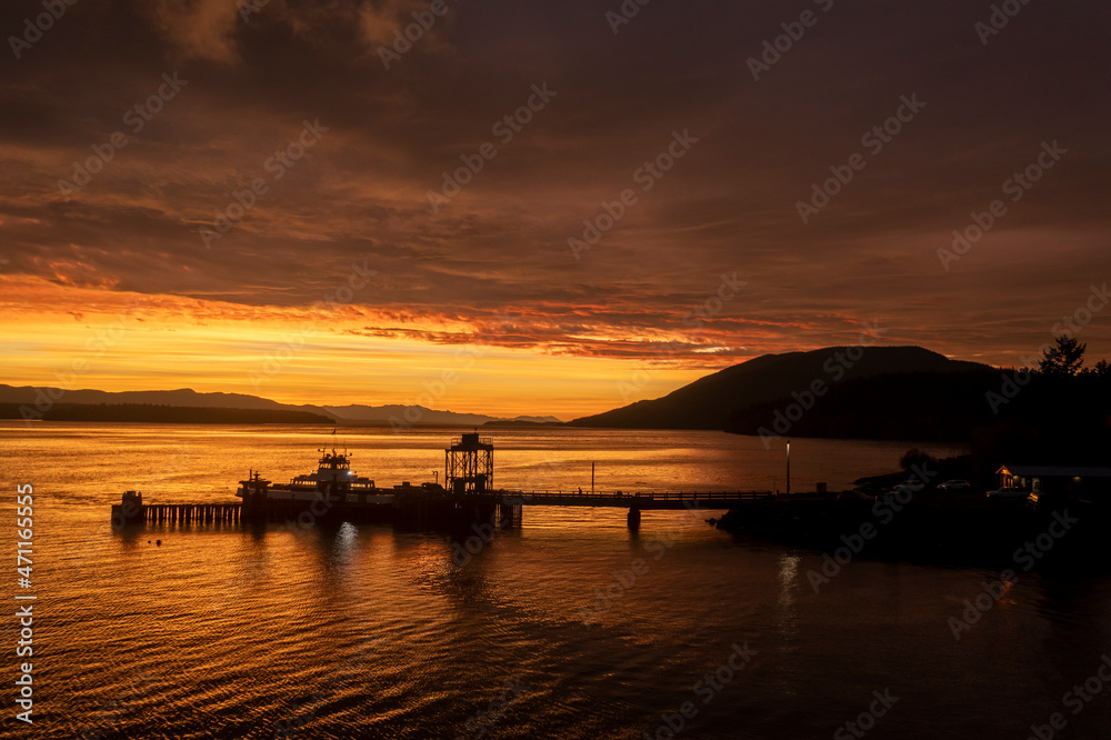 Ferry Boat Servicing a Small Island Near Bellingham, Washington. Aerial drone view captures a spectacular sunrise and cloudscape. 