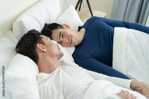 Asian handsome man gay couple lying down on bed and look at each other.  © Kawee