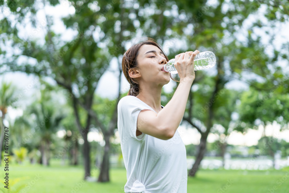 Asian young girl athlete drink bottle of water after exercise in park. Asian young girl athlete drink bottle of water after exercise in park.