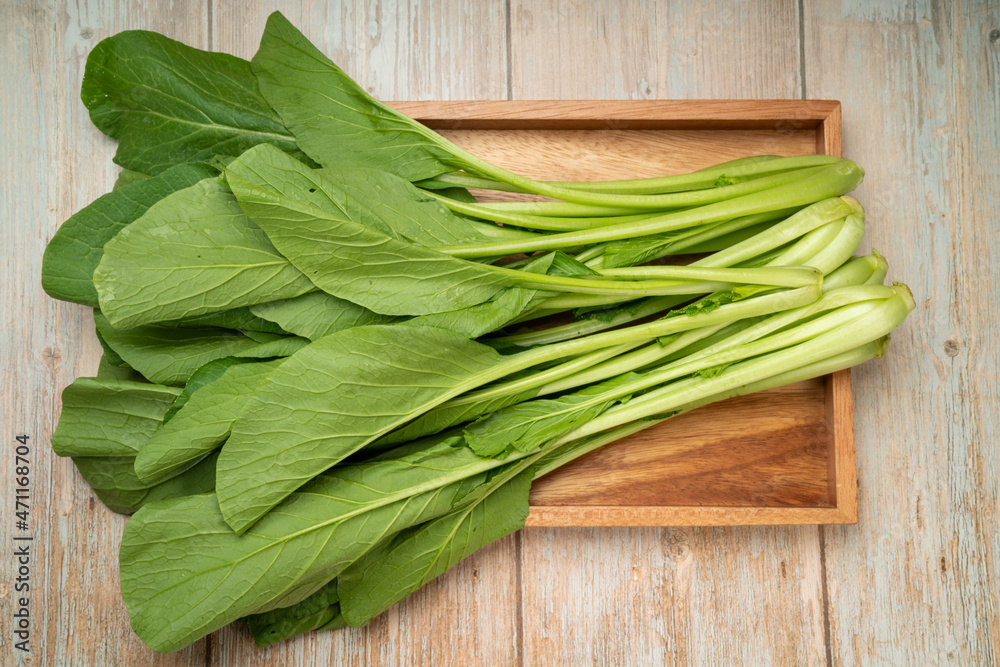 Fresh Chinese cabbage or Choi Sum, Chinese Flowering Cabbage in a wooden tray ready to cook. Fresh Chinese cabbage or Choi Sum, Chinese Flowering Cabbage in a wooden tray ready to cook.