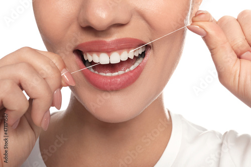 Woman flossing his teeth on white background  closeup. Dental care