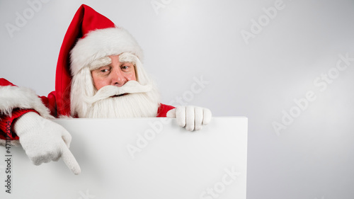 Santa Claus points to an empty white space. Promotional offer for Christmas. © Михаил Решетников