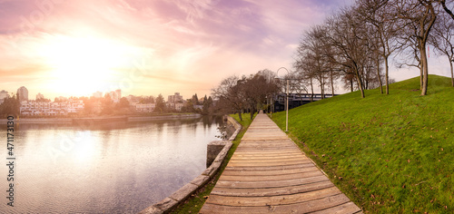 Wooden path in a modern city park during sunny fall season. Sunset Sky Art Render. Located in Granville Island  Vancouver  British Columbia  Canada.