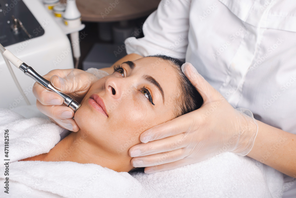 Close-up portrait of woman getting facial hydro microdermabrasion peeling treatment at cosmetic beauty spa clinic. Medical treatment. Rejuvenation treatment.