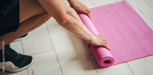 Εκτύπωση καμβά Close portrait of man's hands unrolling exercise mat while preparing for workout at home