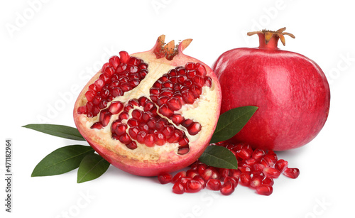 Ripe pomegranates with green leaves on white background