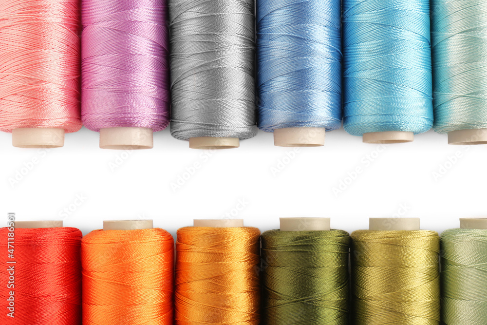 Set of colorful sewing threads on white background, flat lay. Space for text Set of colorful sewing threads on white background, flat lay. Space for text