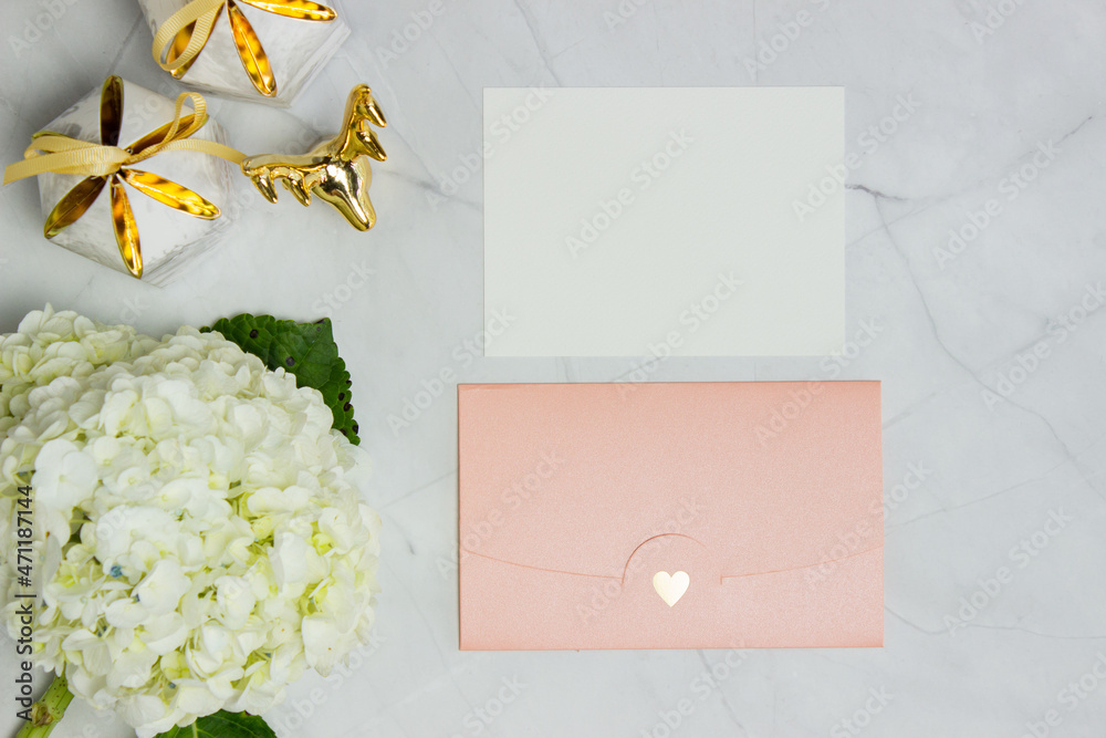 Pink envelope with card and flower with golden box over the marble background. Pink envelope with card and flower with golden box over the marble background.