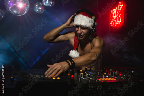 DJ Santa mixing up some Christmas cheer. Disco light around fun, colorful atmosphere.