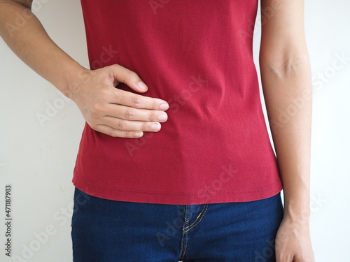 Asian woman suffers lateral abdominal pain due to salpingitis. health concept. closeup photo, blurred. photo