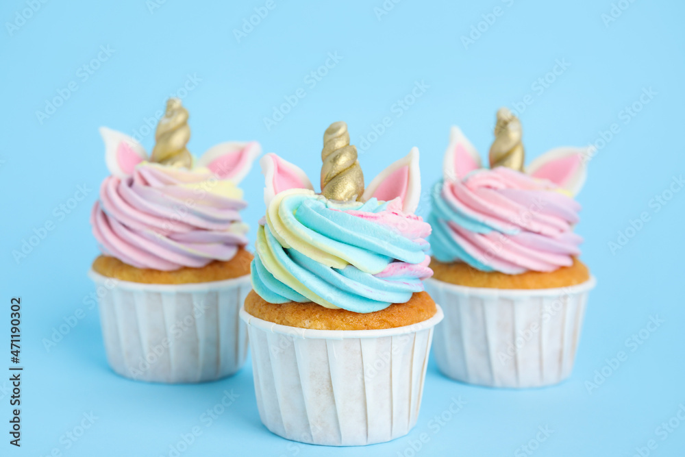 Cute sweet unicorn cupcakes on light blue background